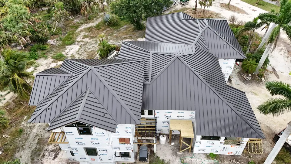 Dark standing seam metal roof on a new build by Providential